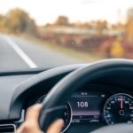 Steering wheel in a car close up, high speed driving on the road.