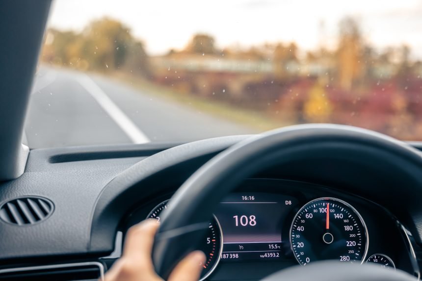 Steering wheel in a car close up, high speed driving on the road.